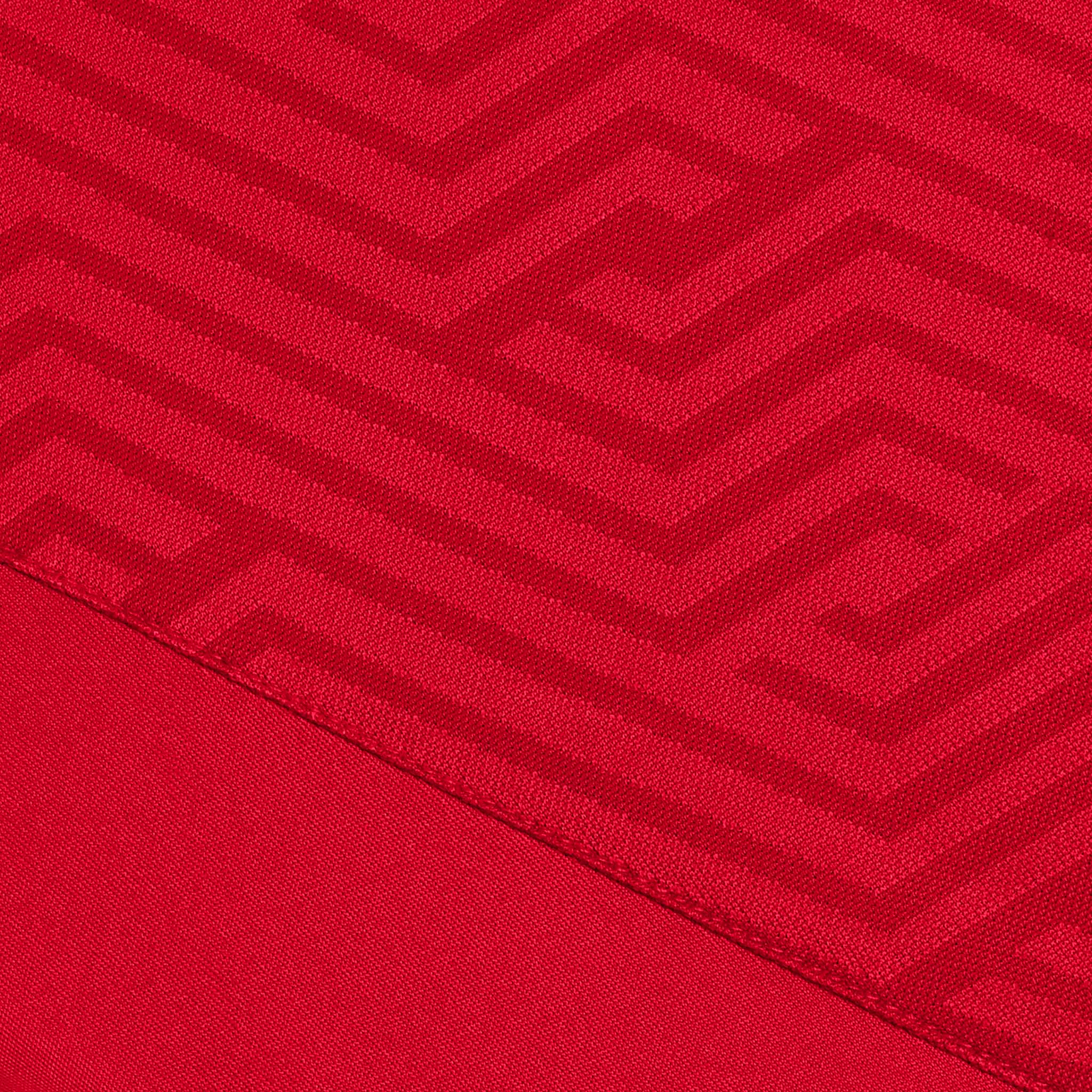 Nærbillede af rød Player shirt S/S Monaco v24, Match & Training wear, med geometrisk zigzag stofstruktur.