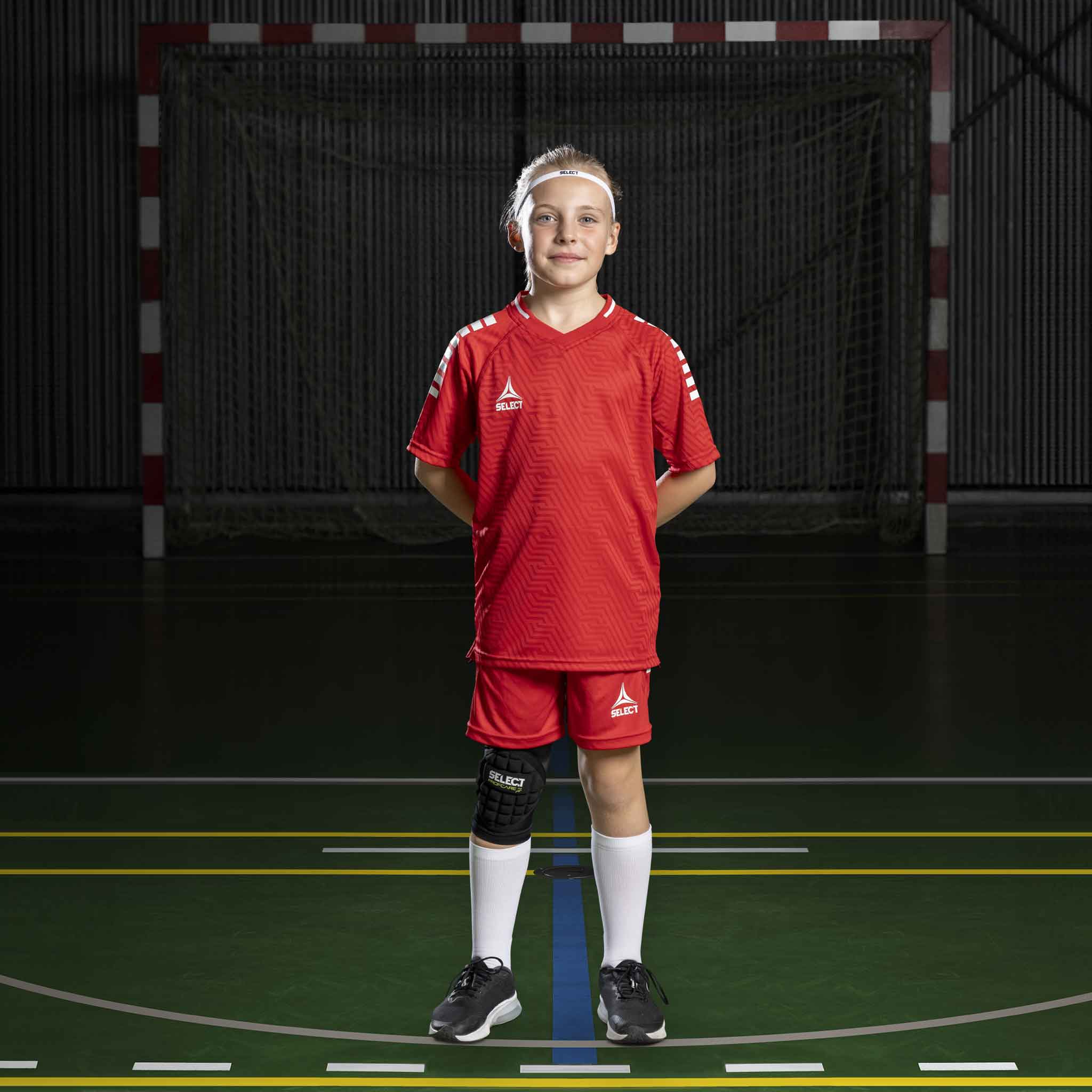 Håndbolddreng i røde Player shorts Monaco v24, Match & Training-tøj, set forfra på indendørsbane.