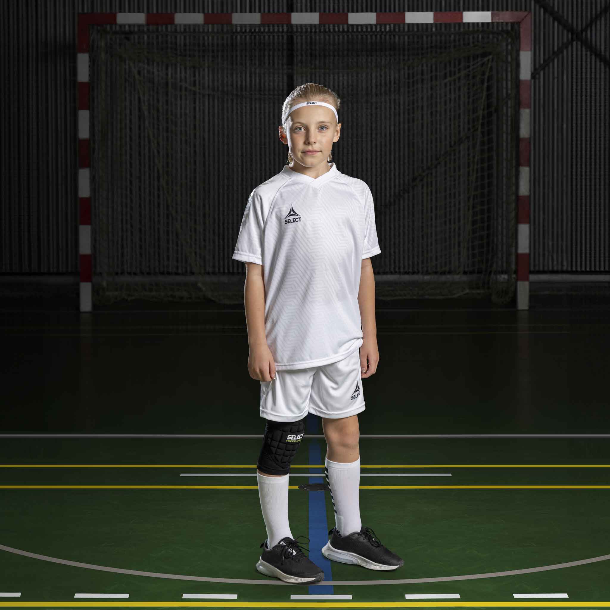 Håndboldpige i hvide Player shorts Monaco v24 og matchende trøje, Match & Training wear, på indendørs bane.