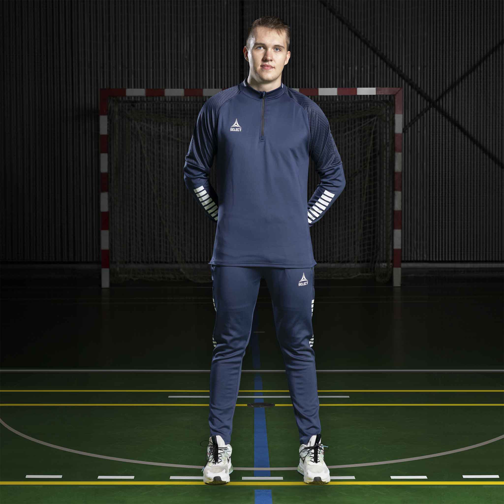 Mandlig håndboldspiller i navy Training sweat 1/2 zip Monaco v24, Match & Training wear, forfra på banen.