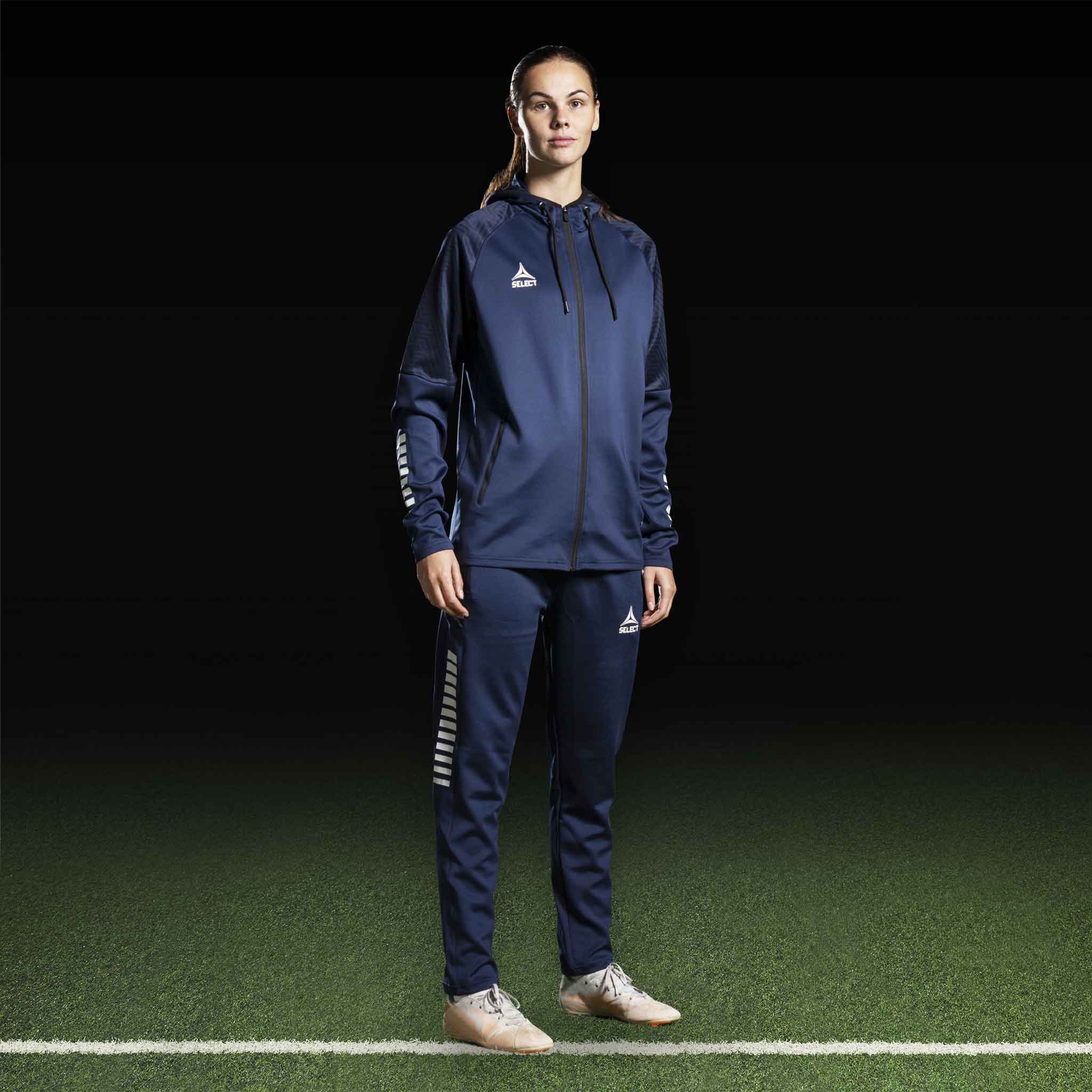 Kvindelig fodboldspiller i navy Zip hoodie Monaco v24, Match & Training wear, forfra med hvide logodetaljer.