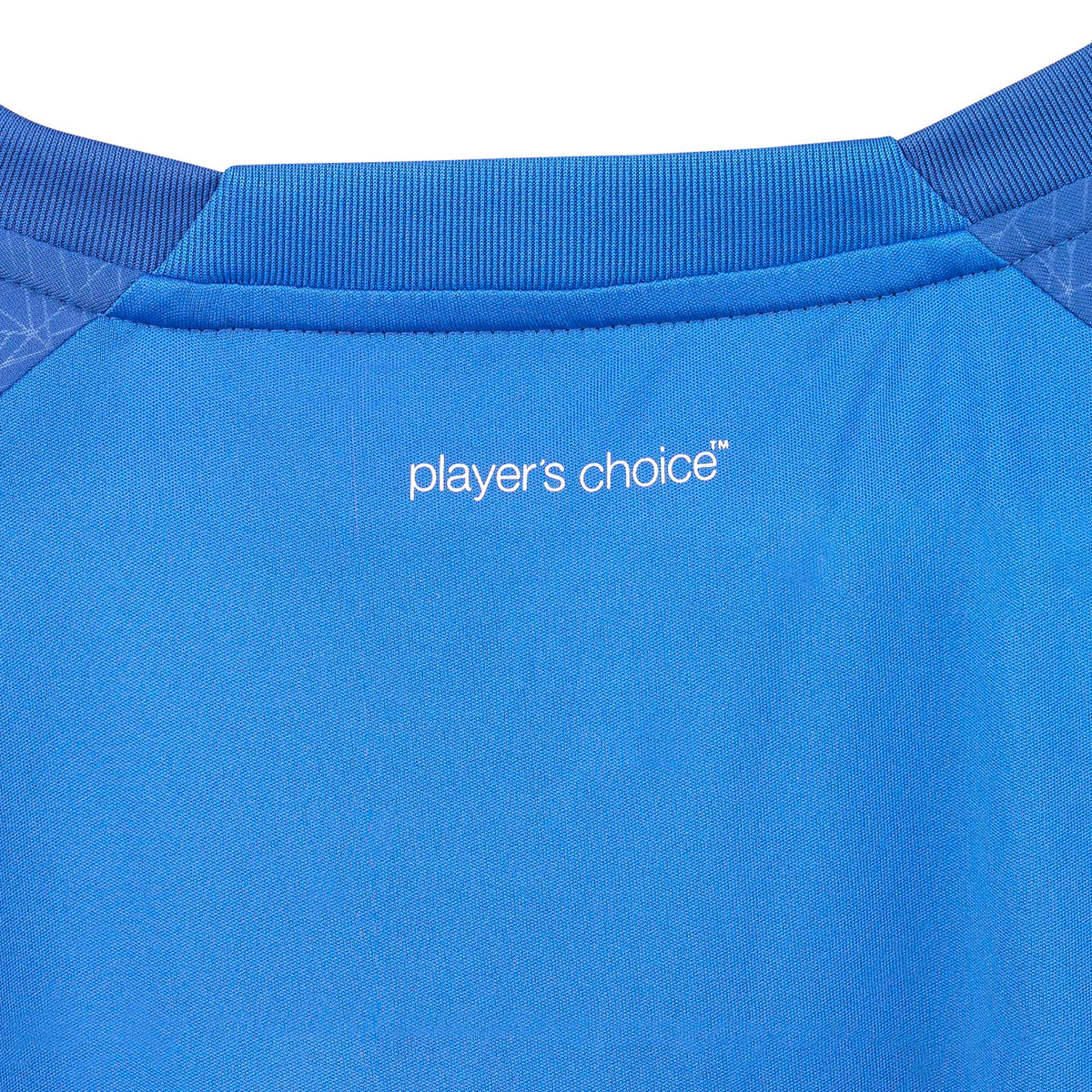 Nærbillede af blå Player shirt S/S Spain woman v25, Match & Training wear, hvidt "player's choice"-logo og kravedetalje.