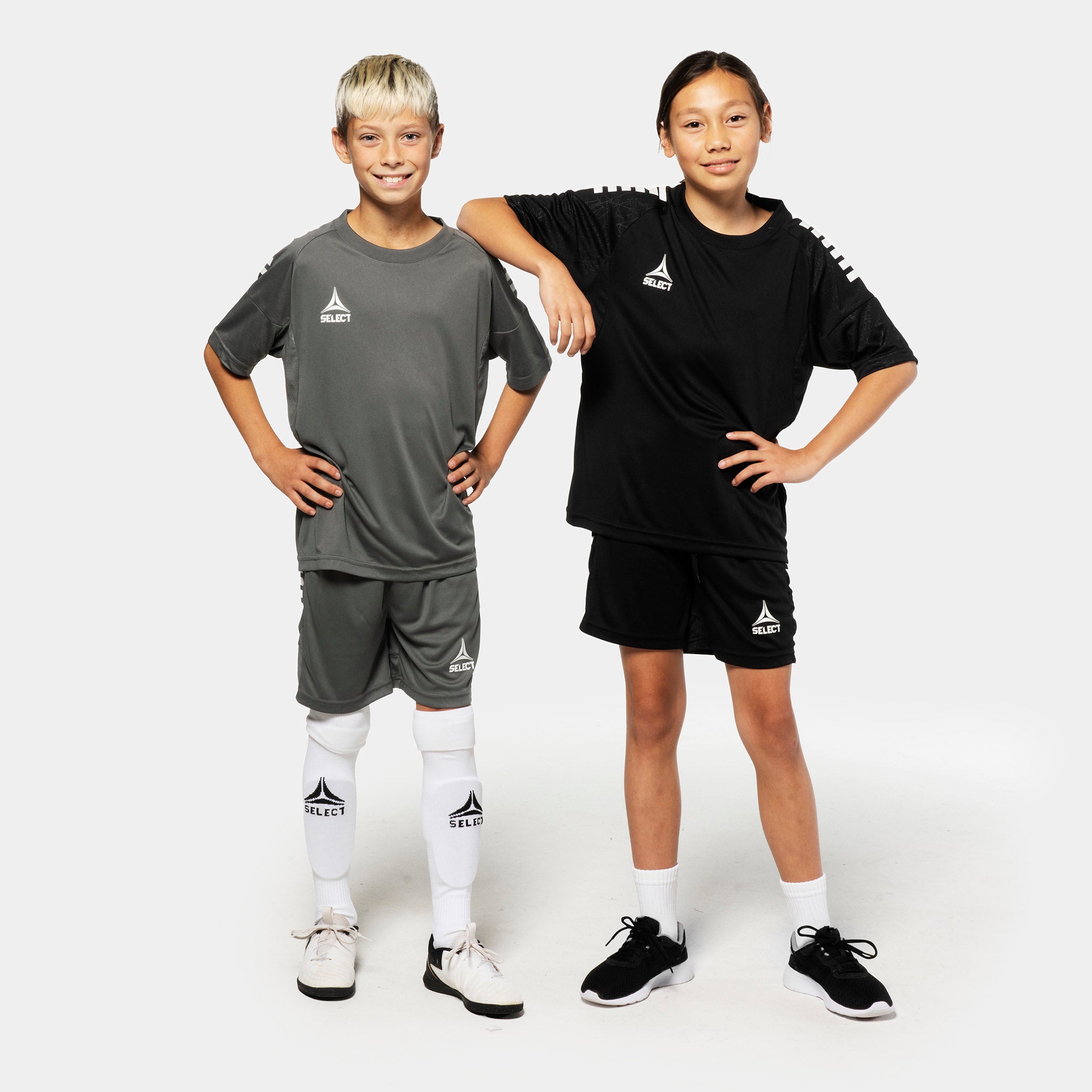 Dreng og pige fodboldspillere i grå og sorte Player shorts Spain v25, Match & Training tøj, set forfra.