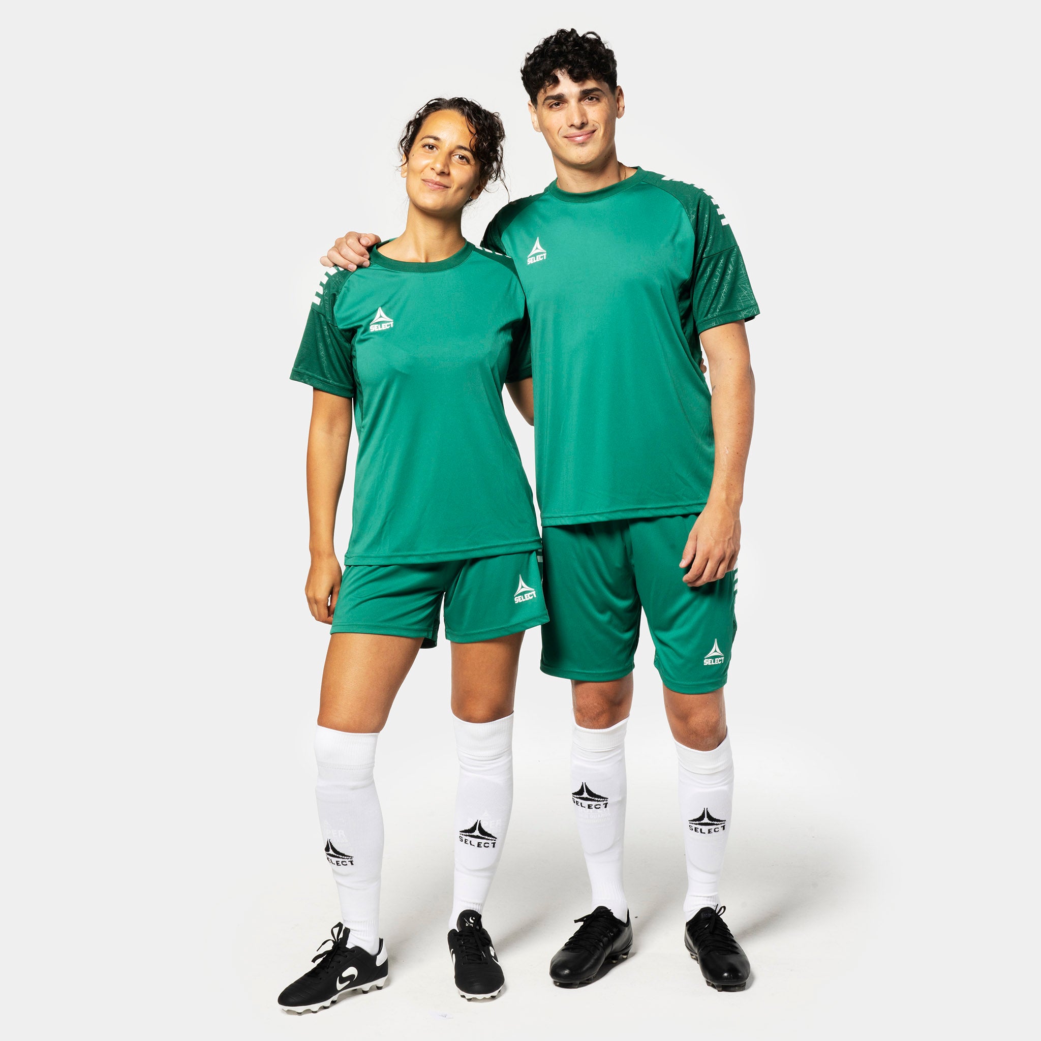 Kvindelig og mandlig fodboldspiller i grønne Player shorts Spain v25, Match & Training wear, med matchende trøjer og hvide strømper.