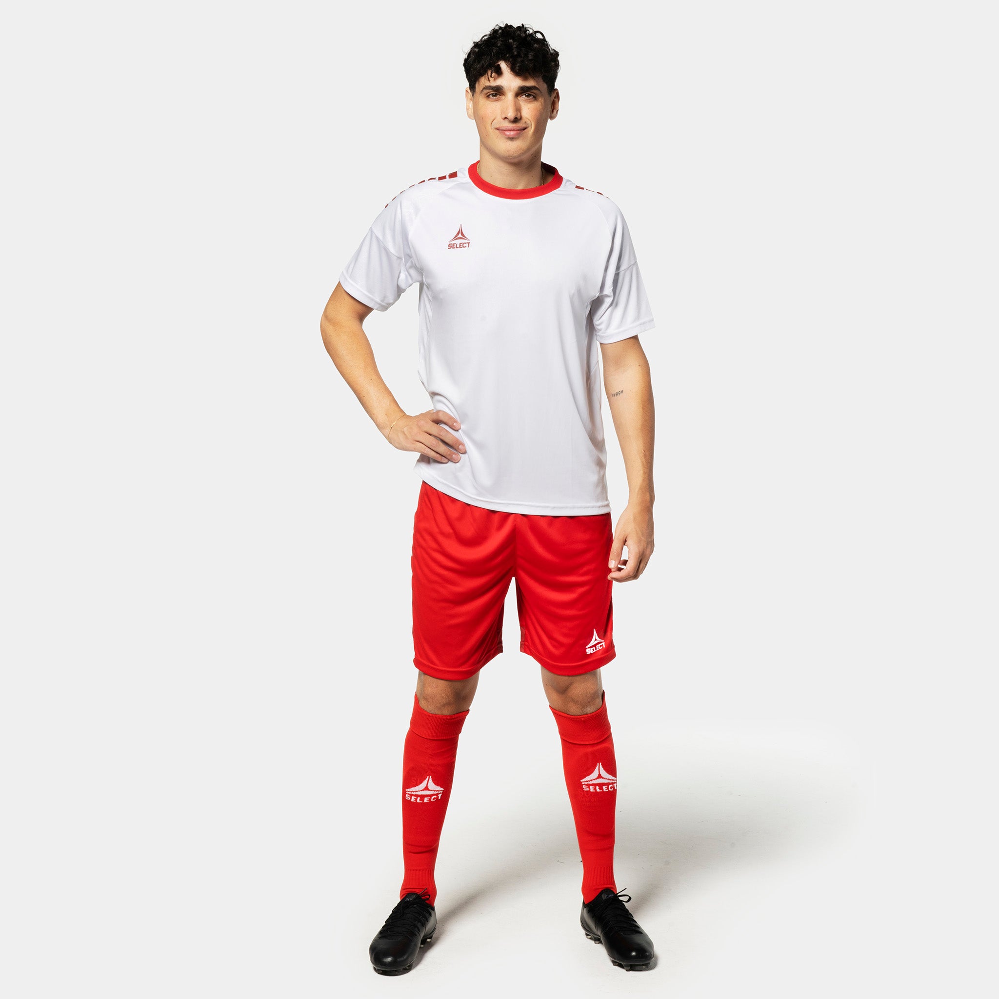 Mandlig fodboldspiller i hvid trøje, røde Player shorts Spain v25 og røde strømper. Match & Training wear.