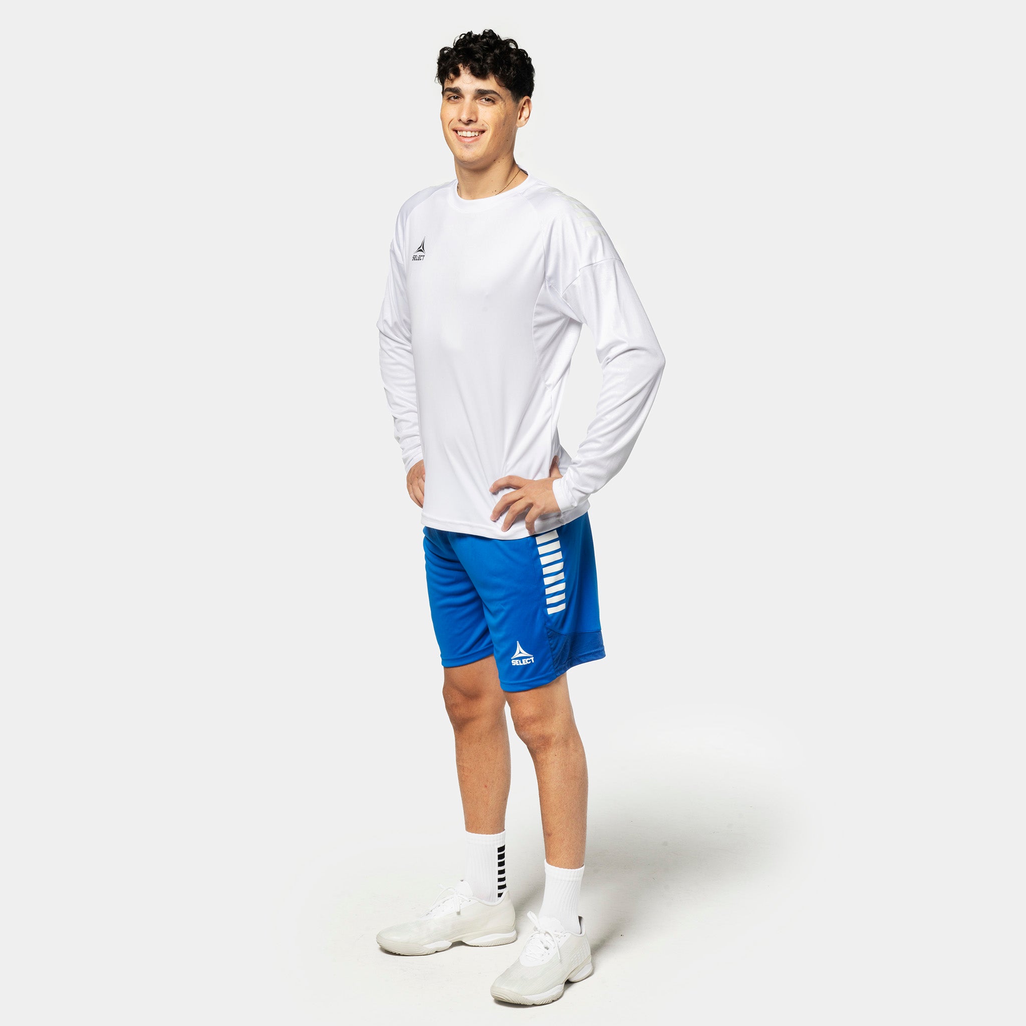 Mandlig fodboldspiller i hvid Player shirt L/S Spain v25 og blå shorts, Match & Training wear.
