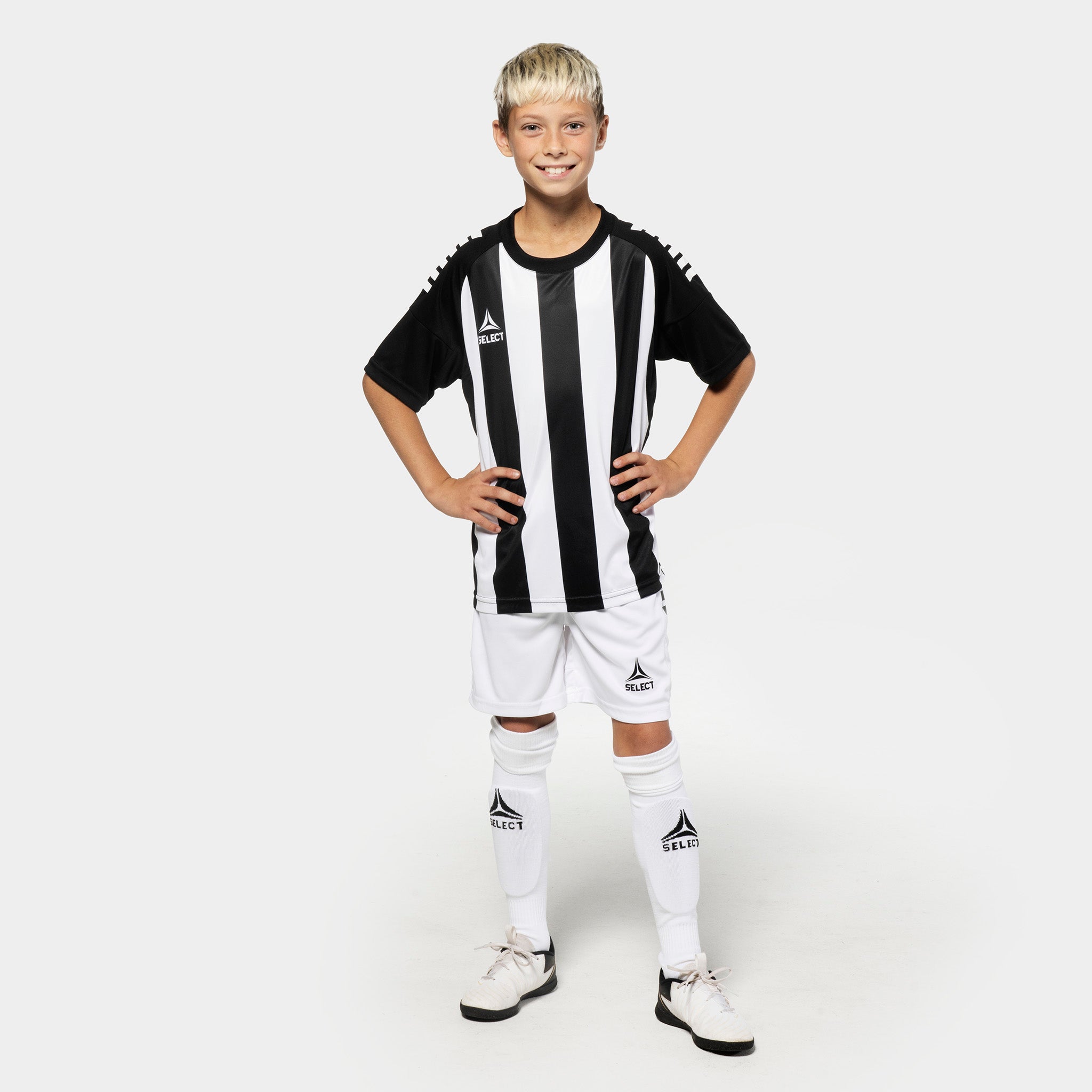 Dreng fodboldspiller i sort-hvid stribet Player shirt S/S Spain v25, Match & Training tøj, med hvide shorts og strømper.