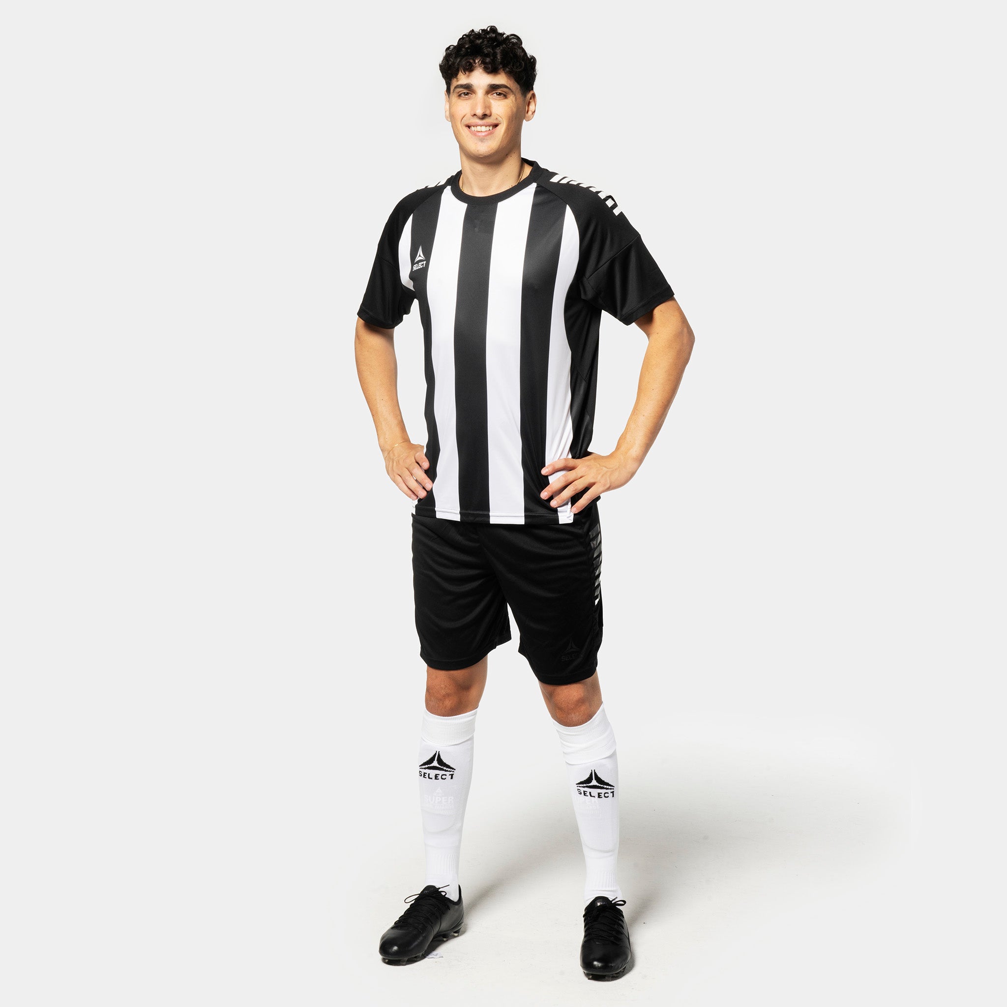 Mand i sort-hvid stribet Player shirt S/S Spain v25, sorte shorts, hvide strømper. Football Match & Training wear, set forfra.