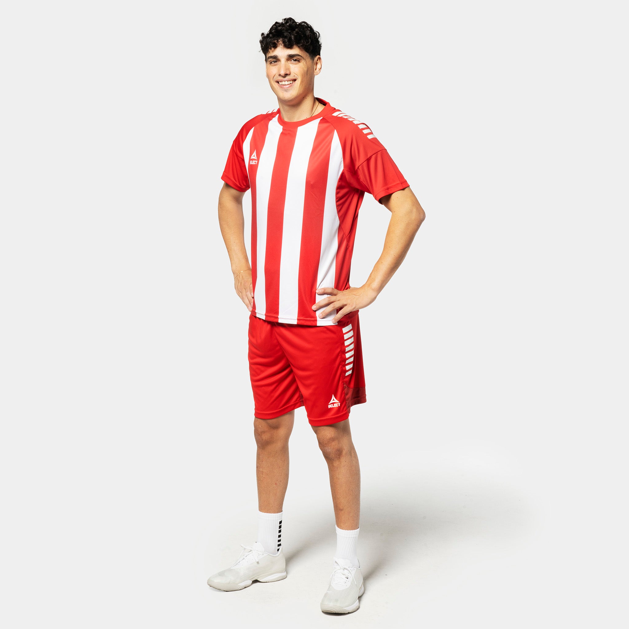 Mandlig fodboldspiller i rød- og hvidstribet Player shirt S/S Spain striped v25 med røde shorts, Match & Training wear.