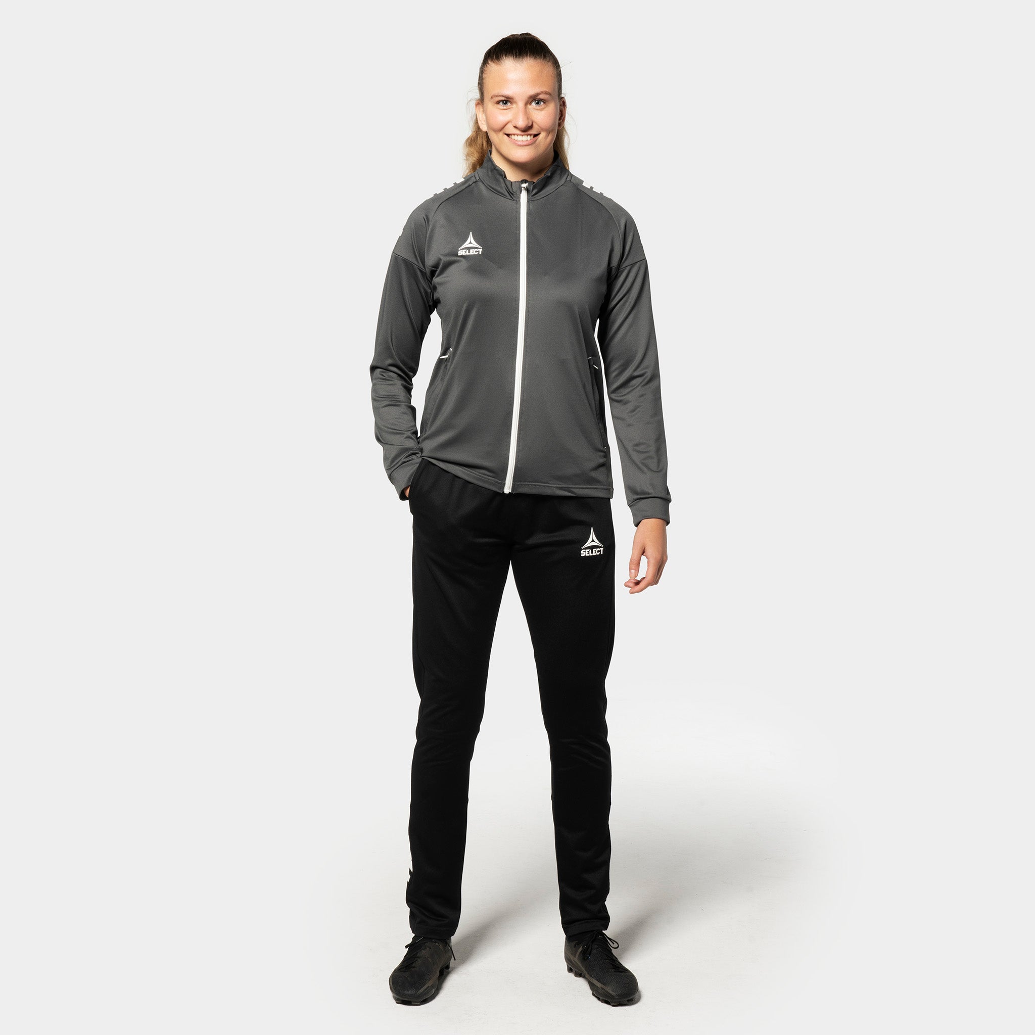 Kvindelig fodboldspiller i grå-hvid Training zip jacket Spain woman v25, Match & Training wear, sorte bukser, set forfra