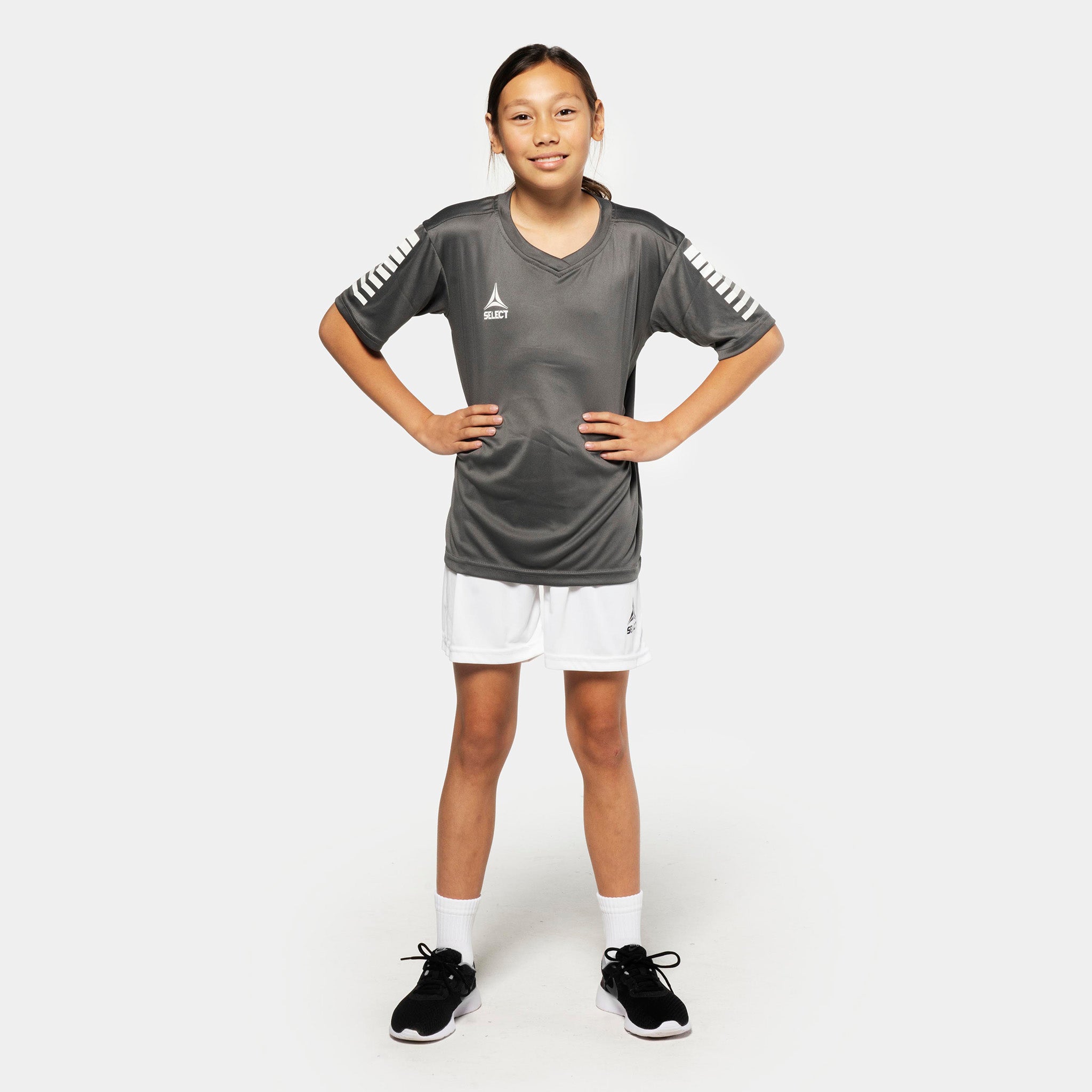 Pige fodboldspiller i grå trøje og hvide Player shorts Pisa, Match & Training wear, set forfra.