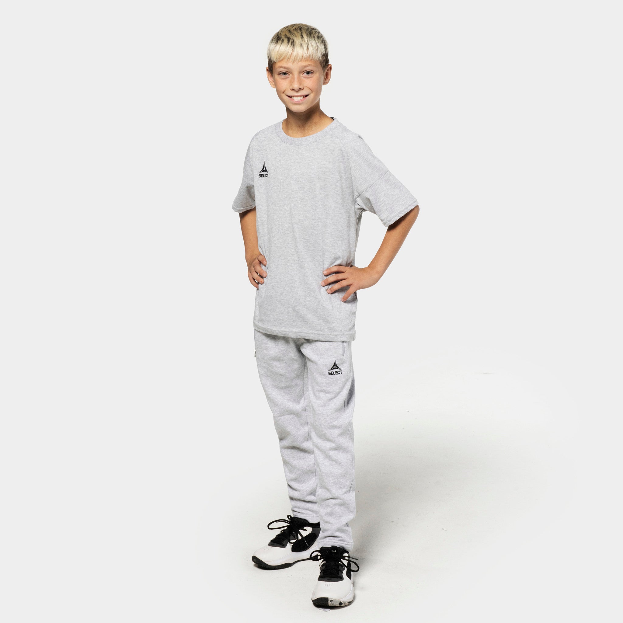 Dreng fodboldspiller i grå Sweat pants Oxford v25 og grå t-shirt, fritidstøj, set forfra.