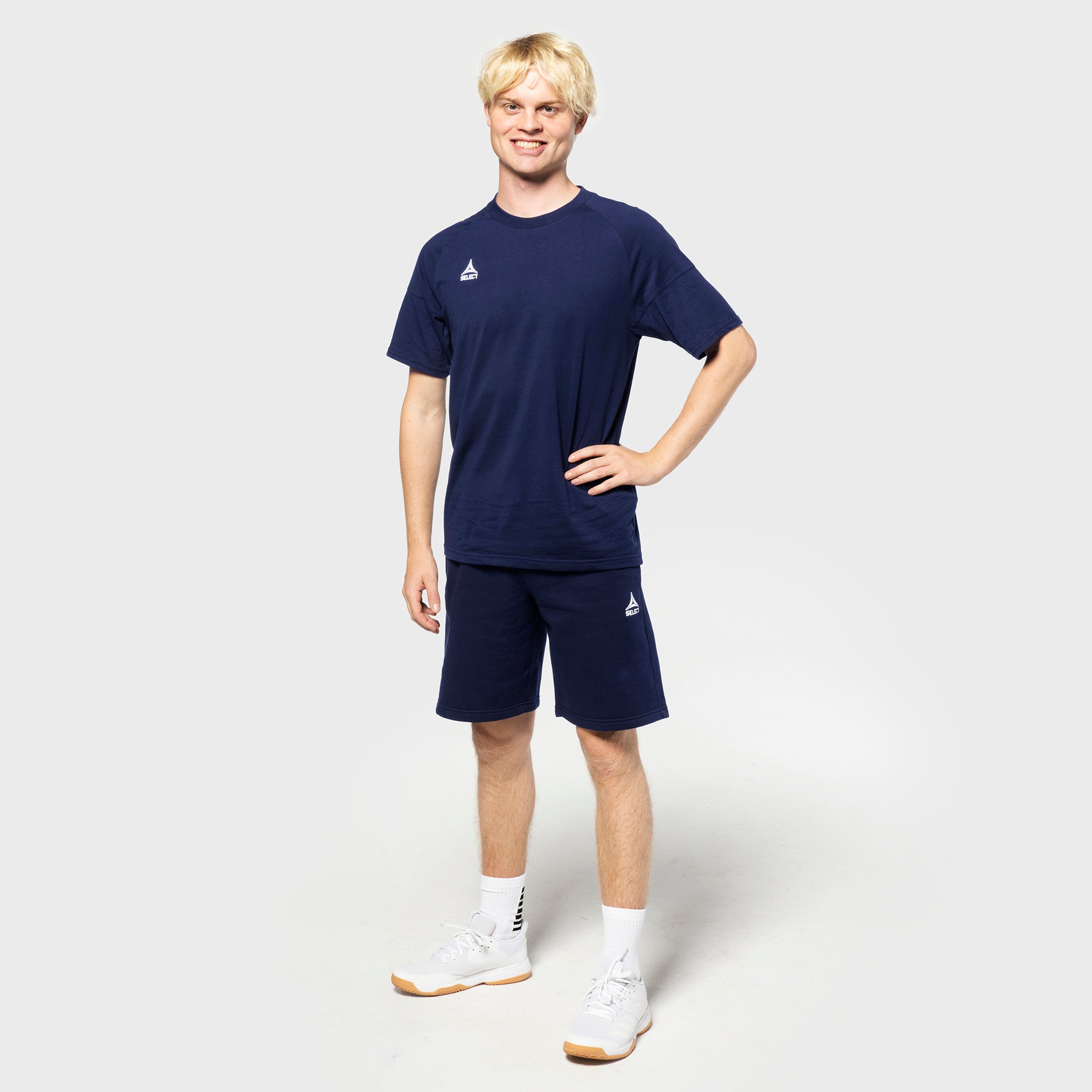 Mandlig fodboldspiller i marineblå Sweat shorts Oxford v25 og marineblå t-shirt, fritidstøj, set forfra.