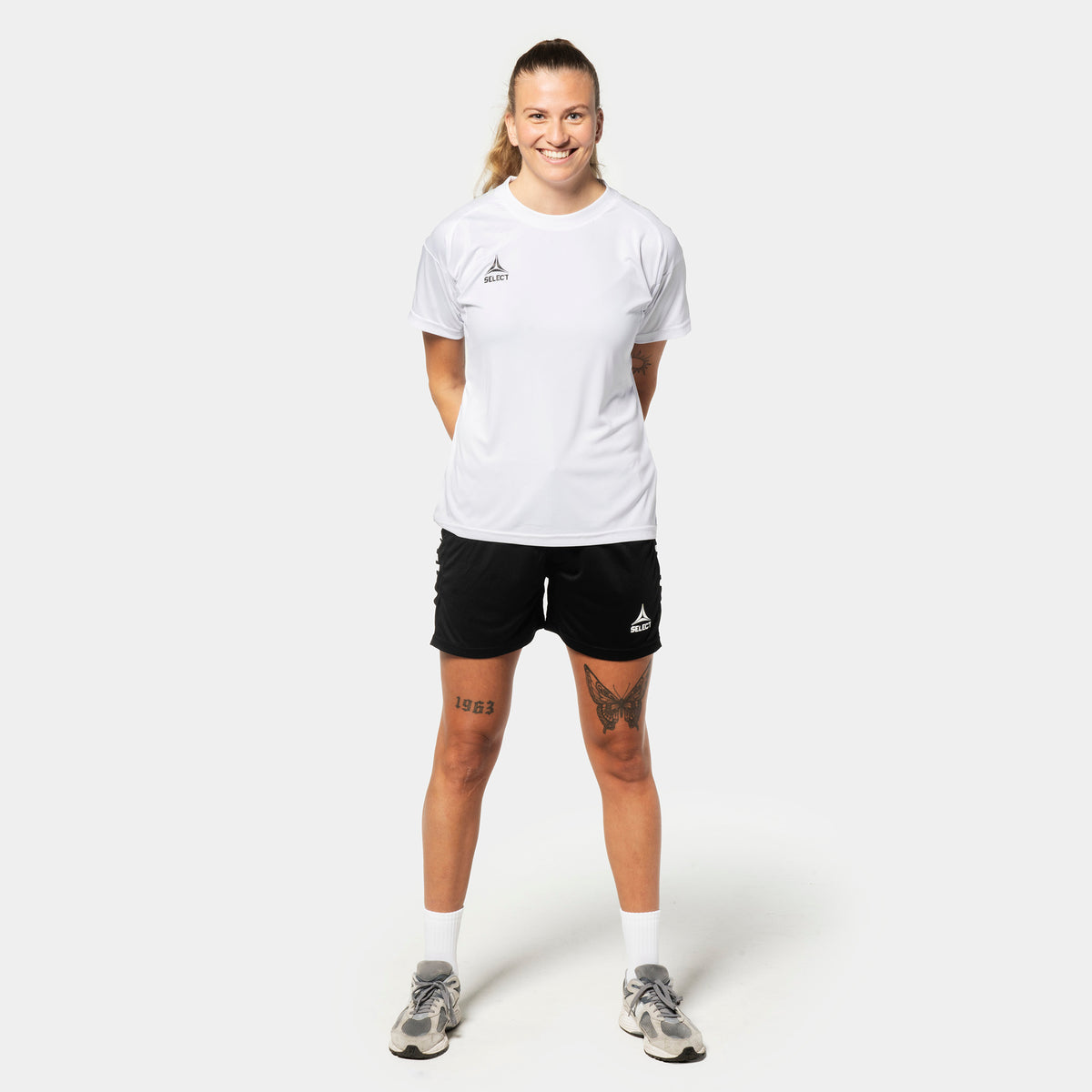 Kvindelig fodboldspiller i hvid Player shirt S/S Spain woman v25 og sort Player shorts Spain woman v25, Match & Training wear, forfra.