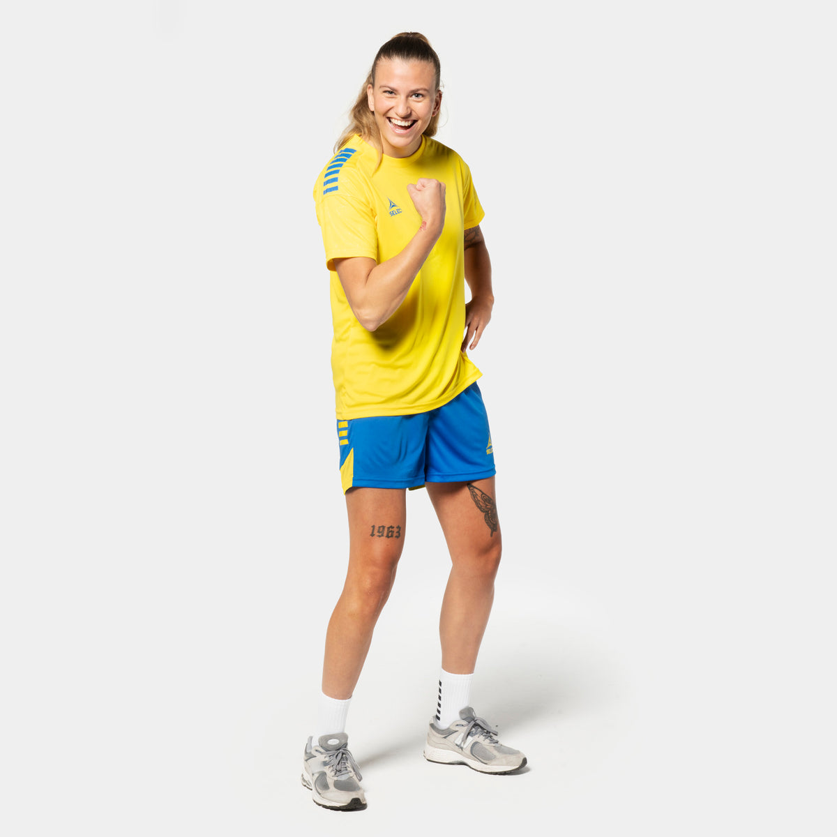 Kvindelig fodboldspiller i gul Player shirt S/S Spain woman v25, blå Player shorts Spain woman v25, Match & Training wear, forside